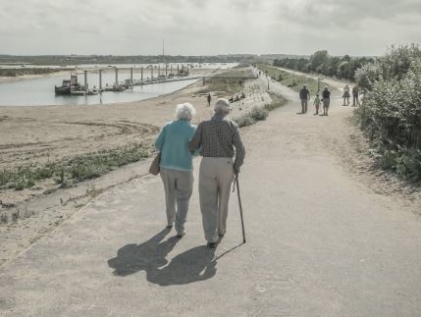 Seniors walking on beach.