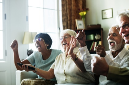 Senior people watching television together