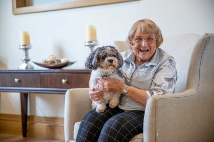 Senior with dog on lap.