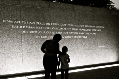 adult and child standing in front of MLK Jr. quote