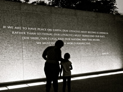adult and child standing in front of MLK Jr. quote